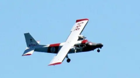 A picture of a red and white aircraft. It is the channel islands air search aircraft. 