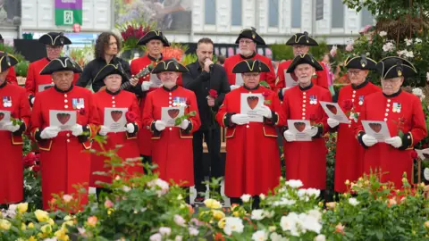 PA Media Alfie Boe performs with the Chelsea Pensioners singing group to celebrate the launch of the Harkness Roses Chelsea Pensioner rose