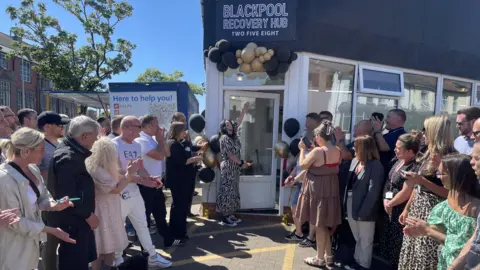 Crowds gather outside shop building where recovery hub is based in Blackpool