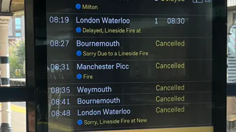 A departures board showing cancelled and delayed services