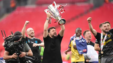 Adam Davy/PA Wire Russell Martin lifts the Championship play-off trophy after his side won the final at Wembley