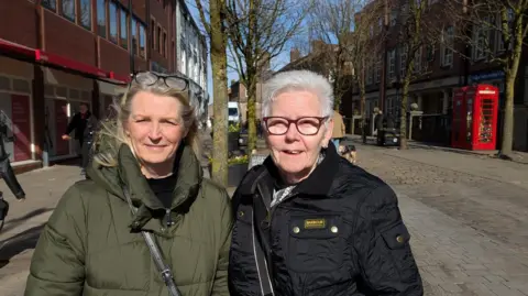 Two retired women in a hot coat on Nicola Tomlinson and Linda Village, McClassfield Market Square