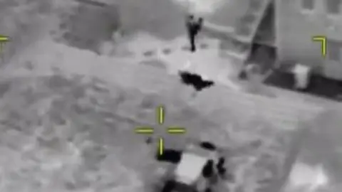 South Yorkshire Police Still from police helicopter video of men leaving the car that had been followed by South Yorkshire Police. Black and white thermal image of a man (left) and a car (right).