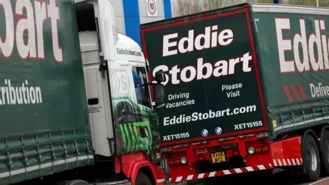 Two green lorries which has 'Eddie Stobart' written on the sides. 