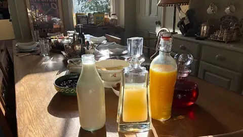 MELANIE CABLE-ALEXANDER Juice and milk on a shared breakfast table at Ellesmere House B&B