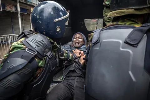 AFP A protester being pushed into a police van.