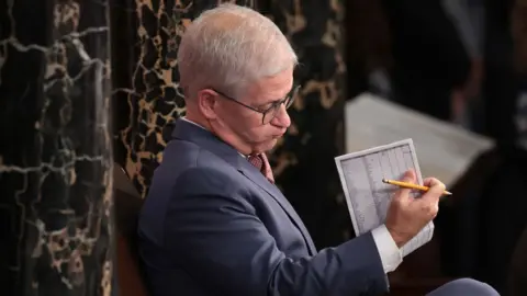 Getty Images Patrick McHenry looks over a vote tally in the House