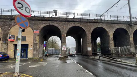 Richard Smith/BBC A wide shot of the viaduct showing five of its arches. A white van is travelling through one, while a man walks through another