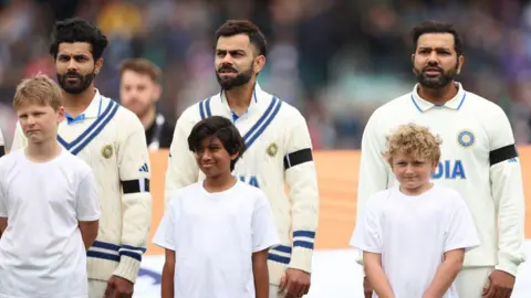 Getty Images Ravindra Jadeja, Virat Kohli and Rohit Sharma of India stand during the national anthem during day one of the ICC World Test Championship Final between Australia and India at The Oval on June 07, 2023 in London, England. 