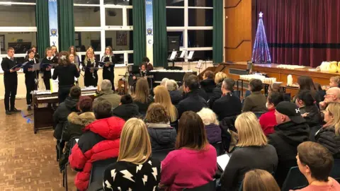 Eirias High School Pupils singing in a choir in a auditorium of seated adults