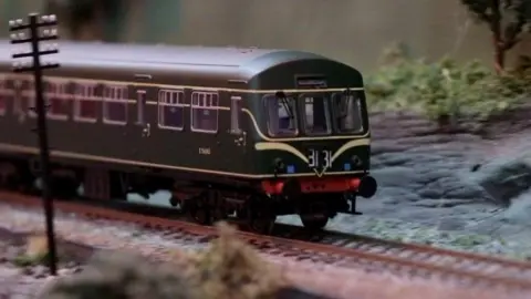 A dark green train on a model railway at the club