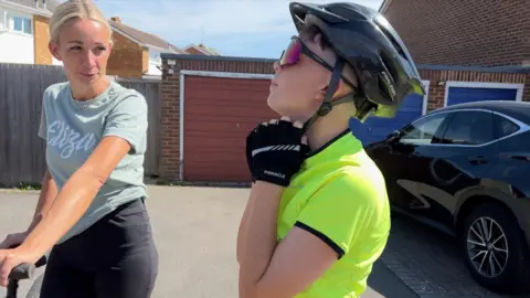 Dexter puts on his cycle helmet watched by his Mum Sam.