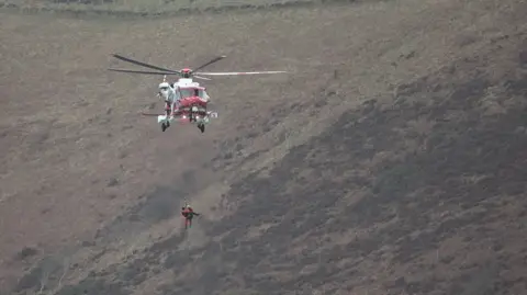 Andy Teal Photography A coastguard helicopter winching a surfer to rescue in Lynmouth, Devon