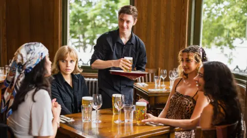 Man serving drinks in a pub