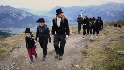 Getty Images Locals, hikers and environmental campaigners attended the "funeral march" for the Pizol glacier