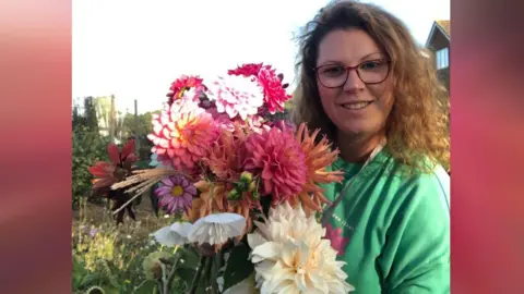 Leanne holding a bunch of colourful flowers 