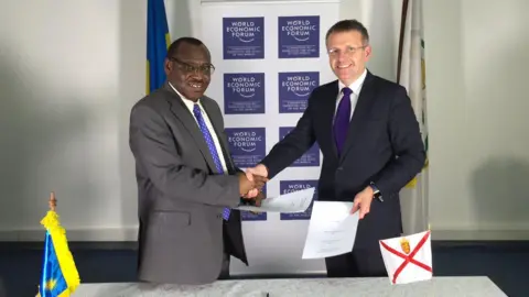 X/Philip Ozouf Philip Ozouf is shaking hands with the Rwandan finance minister at the World Economic Forum. 