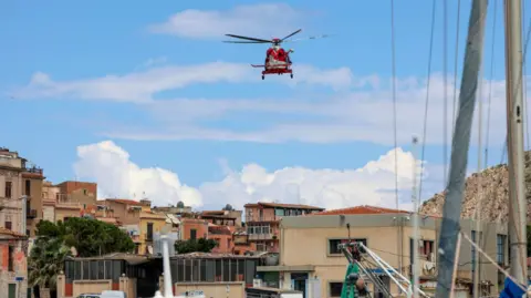 An EPA helicopter arrives to reinforce the rescue operation of the missing yachtsmen, Porticello, Sicily Island.