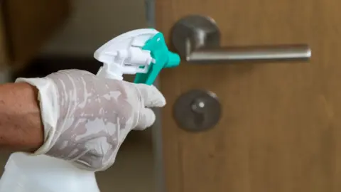 Getty Images Cleaning an office door handle