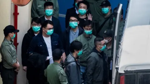 Getty Images Hong Kong pro-democracy activists are escorted into a van as they leave the Lai Chi Kok