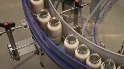 Coca-Cola Paper bottles at the filling plant, moving along rollers on the assembly plan