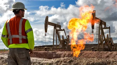 Getty Images A gas flare is seen at an oil well site in 2013 outside Williston, North Dakota