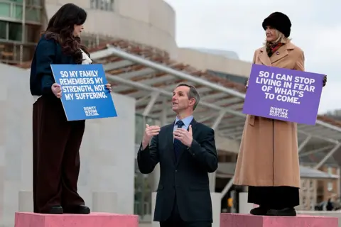 Getty Images Terminally ill women Lisa Fleming, Tish McEwan and Liam McArthur MSP attend a photocall outside the Scottish Parliament in favour of the assisted dying bill in Scotland