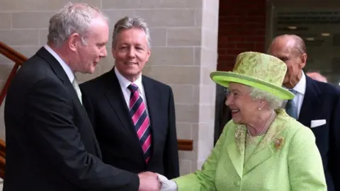 PA Media Martin McGuinness, Peter Robinson and the Queen