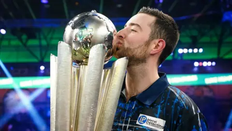 PA Media Luke Humphries kissing trophy