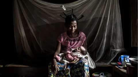 Sara holds her child