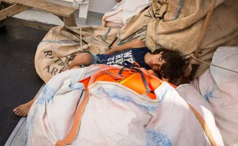 MAUD VEITH/ AFP A rescued migrant sleeping at the Aquarius rescue ship