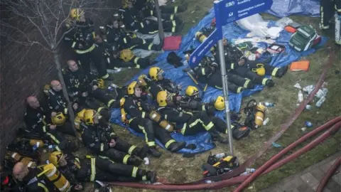 London News and Pictures Tired fire fighters