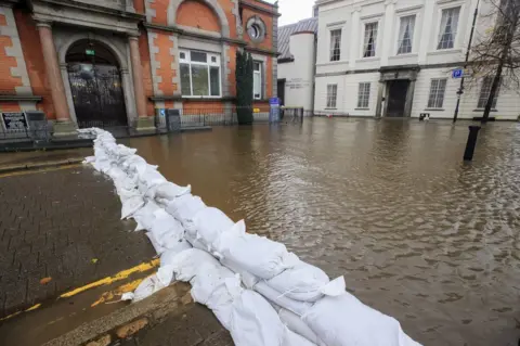 PA Media A line of sandbags holds back floodwater outside Newry Town Hall