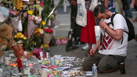 PA People look at tributes at Notting Hill Methodist Church near Grenfell Tower