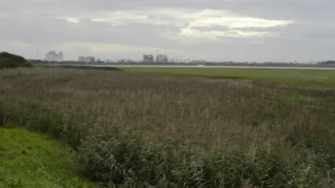 Tom Richardson/Wiki Commons Shot of the ICI site taken far away. The plant can be seen in the distance which is surrounded by low, green fields.