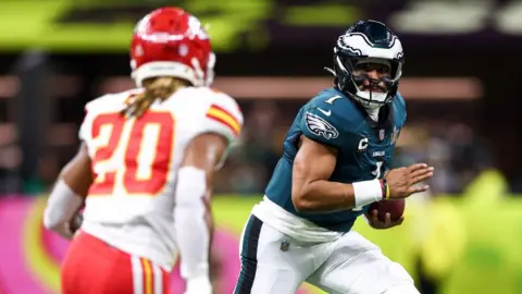 Jalen Hurts - quarterback of the Philadelphia Eagles - runs with the ball past a player from Kansas City Chiefs