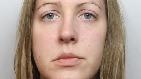 Cheshire Police Lucy Letby stares at the camera in a police mugshot at the time of her arrest