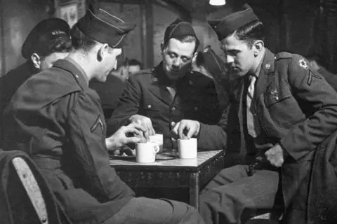 Getty Images A photo taken on 27 January 1944 of American soldiers enjoying a drink at Rainbow Corner, the American Red Cross club for servicemen in London's Piccadilly, during World War Two