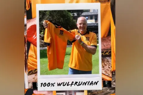 Old Gold Pack Steve Bull is holding one of the shirts in a garden and smiling at the camera. He is also wearing one.