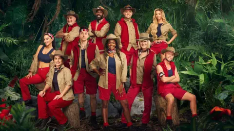 Yoshitaka Kono/PA Press shot of Tulisa, Coleen, Barry, Danny, Melvin, Oti, Alan, Jane, GK Barry & Dean, who took part in series 24 of I’m a Celebrity Get Me Out of Here. The camp mates are dressed in red, blue and brown camp wear. 