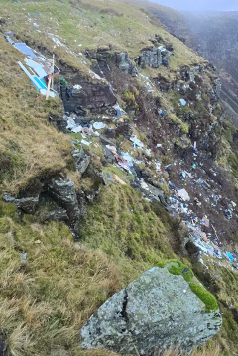 Nathan Dixon Another view of the fly tipped waste down the side of the mountain - this time looking across with the rest of the mountain ridge in the background. 