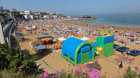 BBC Weather Watchers/mikea Viking Bay in Broadstairs on a sunny day. The beach is very busy, with hundreds of people enjoying the sun.