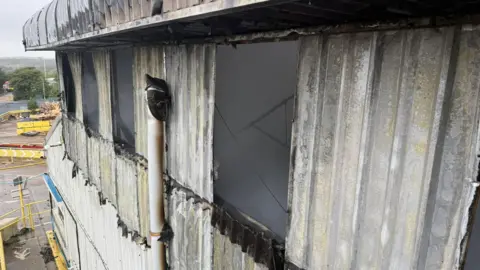 DWFRS The damaged outer walls and windows of a building.