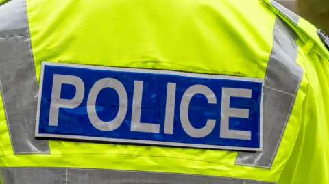 The logo on the back of a reflective jacket worn by UK police.