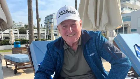 John Jones sitting on a lounge chair at a resort