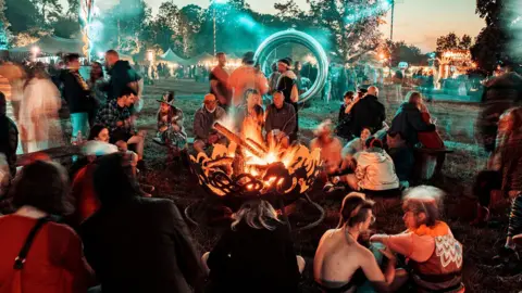 Festival-goers sat around a fire