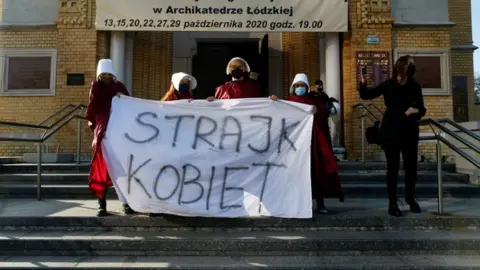 Reuters Protesters hold a banned saying "women's strike" outside a cathedral in Lodz, Poland