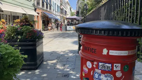 A red British post box on a street in Gibraltar