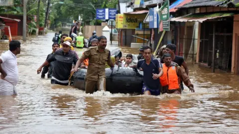 Reuters Rescuers evacuate people from a flooded area to a safer place in Aluva - 18 August