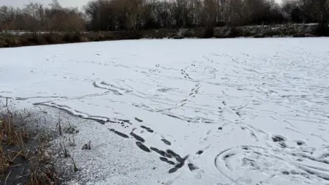 Footprints on snow covering a frozen pond in Newark.
